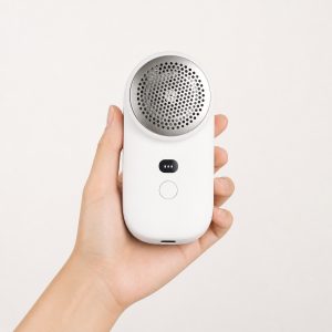 Cloud white rechargeable fabric shaver held in one hand